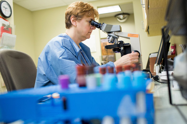 nurse using a microscope